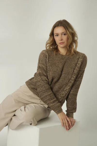 穿着棕色冬季毛衣和米色宽裤的年轻女子的时尚肖像 白色背景 — 图库照片
