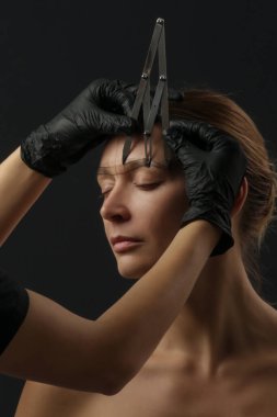 Mikrobleing kaş ölçüsü. Kozmetik uzmanı mükemmel şekilli kaşlar için kalem ve ipliklerle işaretler yapar. Profesyonel makyaj ve yüz bakımı. Kalıcı makyaj, kaş dövmesi.. 