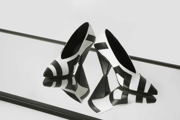 女性优雅尖尖的脚趾V切割中猫咪高跟鞋 黑色和白色皮鞋 产品工作室拍摄与反射镜 — 图库照片