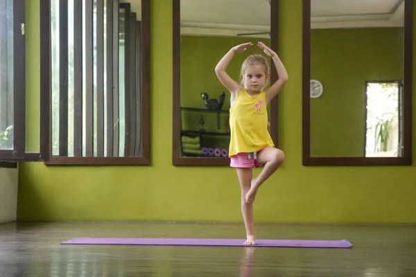 子供のためのヨガ 可愛いです女の子練習ヨガスタジオで 木のポーズ — ストック写真