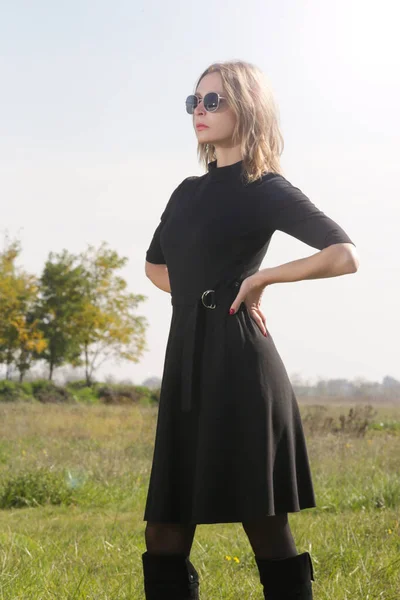草原に黒のポーズで女性モデルの写真のセリエ 自然光と屋外ファッションの肖像画 — ストック写真
