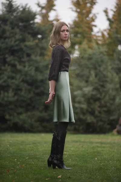 公园里穿着绿色绸缎裙和棕色上衣的女人的户外肖像 — 图库照片