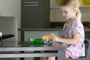 Adorable little girl playing with wooden toys at home