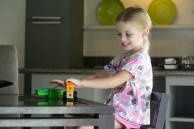 Adorable little girl playing with wooden toys at home