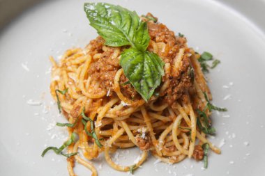 Portion of homemade spaghetti bolognese served in ceramic plate.