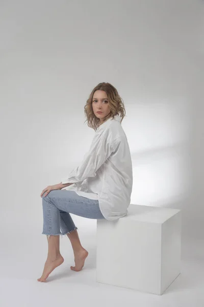 白い綿のボタンダウンシャツと白い背景に青いジーンズの若い女性のファッションの肖像画 — ストック写真