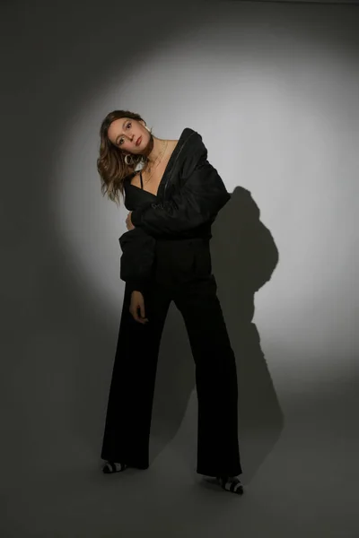 黒の爆撃機のジャケットとパンツを身に着けている美しい女性モデルのファッションの肖像画スポットライト 女性の美しさ ファッション 魅力的なコンセプト — ストック写真