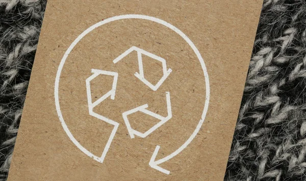 リサイクルアイコンで衣類のタグを閉じます リサイクル製品のコンセプト 廃棄物ゼロ 持続可能な生産 環境への配慮と再利用の概念 — ストック写真