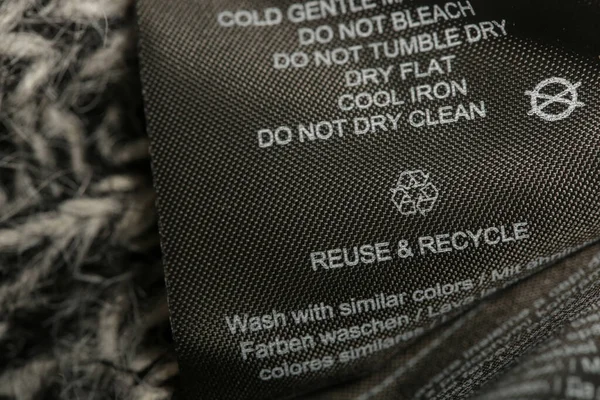 ファブリック組成ラベル ブラックファブリックラベル上の洗浄指示とリサイクル記号 服の上のランドリータグ — ストック写真