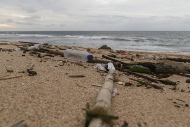 Kumsaldaki plastik çöpler. Plastik kirliliği kavramı. Tek kullanımlık plastik gezegenimizi yok eden ve sularımızı, deniz yaşamlarımızı ve insanlarımızı etkileyen bir insan bağımlılığıdır..