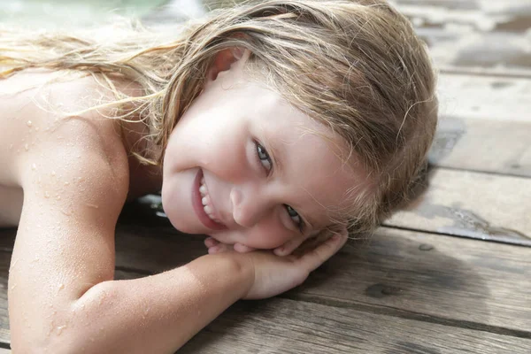 स्विमिंग पूल में गीले बालों के साथ सुंदर खुशहाल 5 साल की लड़की का चित्र स्टॉक इमेज