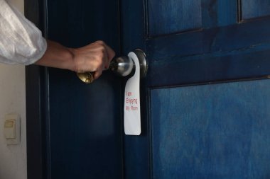 Otel kapısının gizlilik askısı. Künyemin tadını çıkarıyorum. Kapı kolunda asılı duruyor..