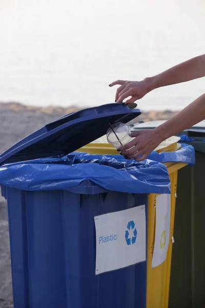 女性の手は リサイクルビンにプラスチックガラスを投げる 水質汚染の低減と省エネルギーによる環境保全の考え方 — ストック写真