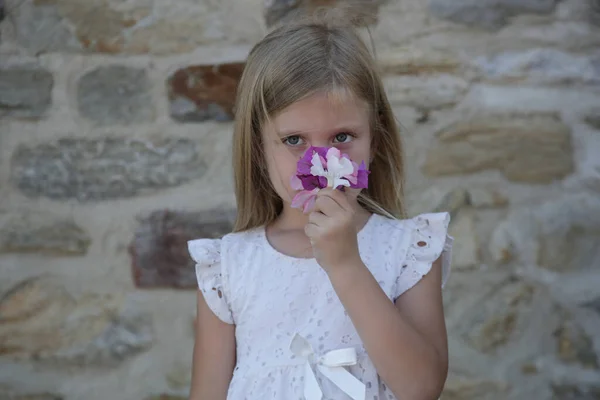 穿着白色夏装 手持地中海小花束的可爱小女孩的画像 — 图库照片