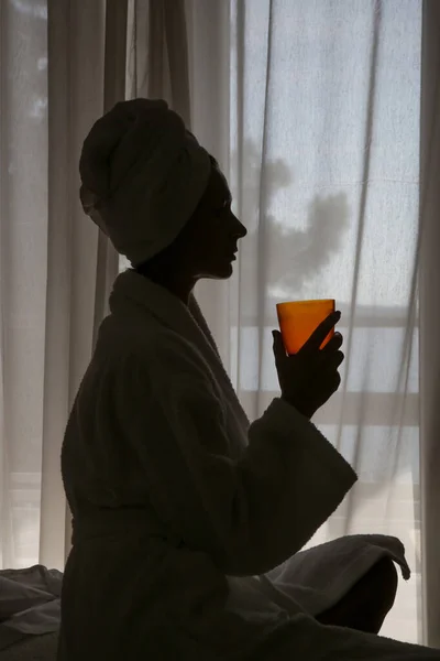 タオルに包まれた若い美しい女性は 窓の横に液体コラーゲンやビタミンサプリメントを飲んで 健康的な朝のライフスタイルの概念 — ストック写真