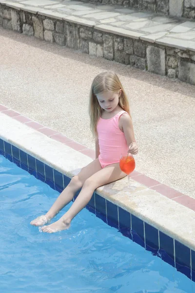暑い夏の日の間にプールサイド 水分補給と健康的な食事療法でリフレッシュドリンクを持っている愛らしい女の子 — ストック写真