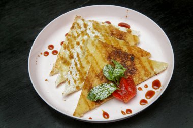 Çikolata şurubuna batırılmış krepler taze çilek ve nane yaprağıyla.