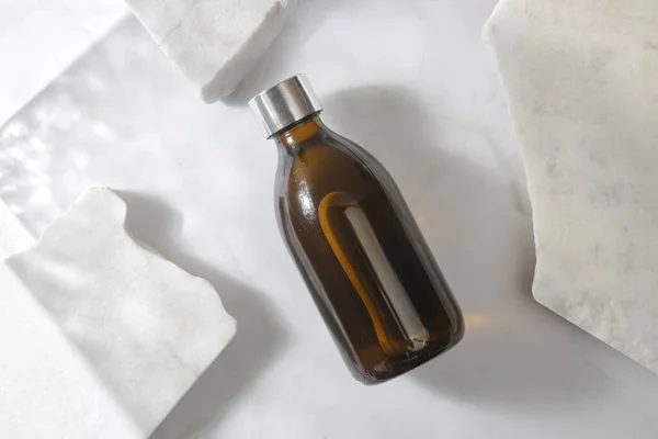 大理石の背景に茶色のガラス化粧品ボトル — ストック写真