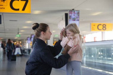 Havaalanında ailesini bulamayan bir çocuğu teselli eden genç bir kadın. Annesi, havaalanındaki uçuştan korkan ağlayan küçük kızı teselli ediyordu..