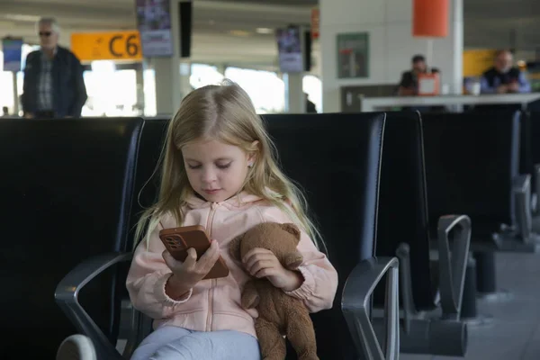Menina Sentada Corredor Partida Aeroporto Segurando Ursinho Pelúcia Brincando Satisfatoriamente — Fotografia de Stock