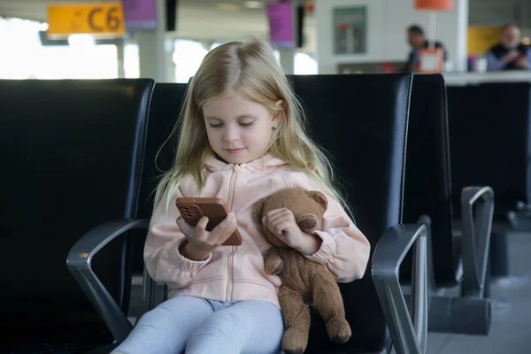 Menina Sentada Corredor Partida Aeroporto Segurando Ursinho Pelúcia Brincando Satisfatoriamente — Fotografia de Stock