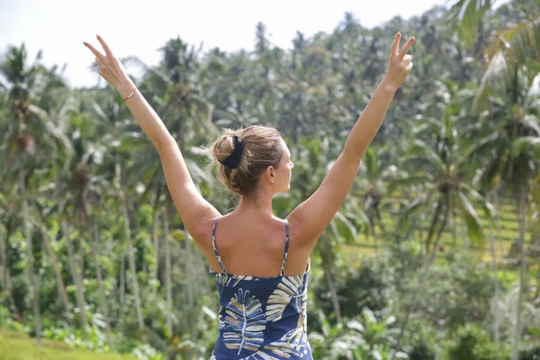 在热带岛屿上举着胳膊 前面有美丽的高大棕榈树的快乐的旅游妇女的倒影 暑假的概念 — 图库照片