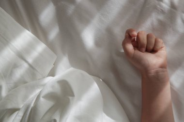 Pamuklu çarşafta çocuk eli. Çocukların uyku zamanı ya da yatma zamanı..