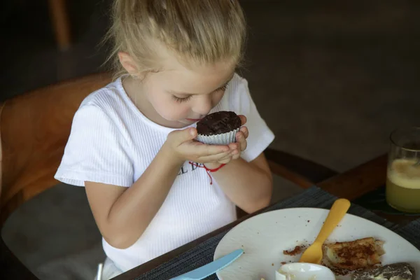 可愛いです5歳の女の子食べるチョコレートマフィンでザレストラン — ストック写真