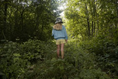 Ormanda yürüyüş yapan, doğa ile zaman geçiren, kırsal alanda deneyimi olan sevimli küçük bir kız.