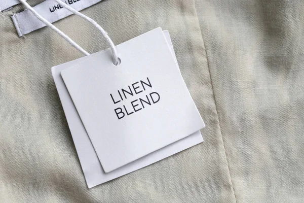 Close up of clothing hang tag. Linen blend product details.