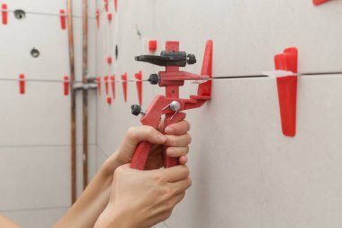 Banyo duvarlarını döşeyen kadın. Düz duvar plastik döşeme sistemi. Banyoya fayans döşeme işlemi. DIY Ev Geliştirme.