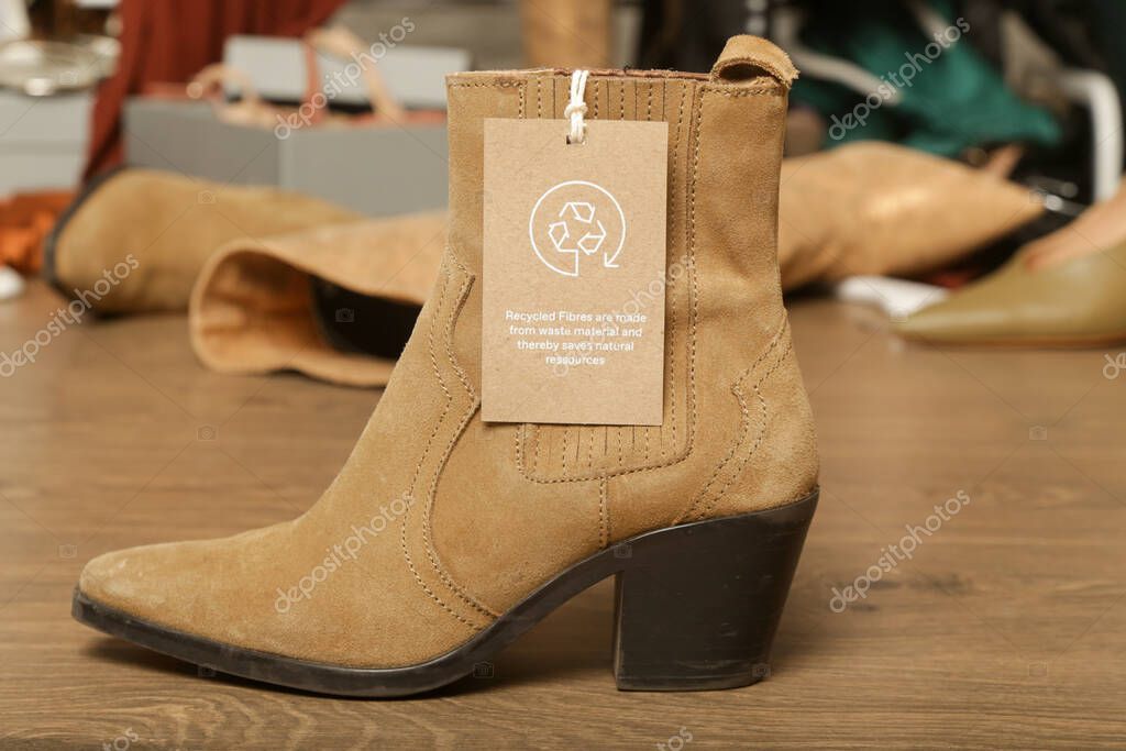Clothing tag with recycle icon on the shoe. Recycling products concept. Zero waste, suistainale production, environment care and reuse concept.