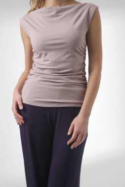 Stüdyo fotoğrafları, rahat basit kıyafetler, kolsuz gömlek ve geniş paçalı pantolon giyen, organik pamuktan yapılmış rahat bir takım elbise.