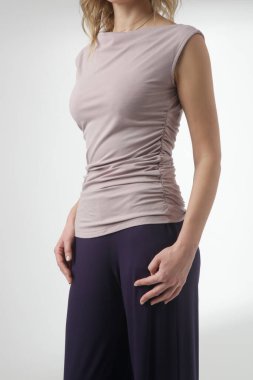 Stüdyo fotoğrafları, rahat basit kıyafetler, kolsuz gömlek ve geniş paçalı pantolon giyen, organik pamuktan yapılmış rahat bir takım elbise.