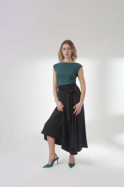 Stüdyo fotoğrafları, sade güzel kıyafetler, pamuk siyah Maxi etek ve yeşil kolsuz bluz giyen genç kadın modeller.