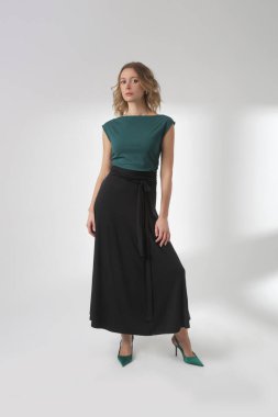 Stüdyo fotoğrafları, sade güzel kıyafetler, pamuk siyah Maxi etek ve yeşil kolsuz bluz giyen genç kadın modeller.