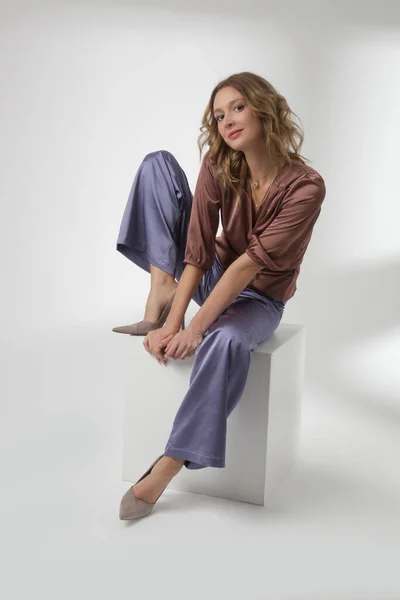 穿着简单漂亮服装 丝绸缎子褐色衬衫和丁香宽腿裤的年轻女模特的摄影棚照片系列 — 图库照片