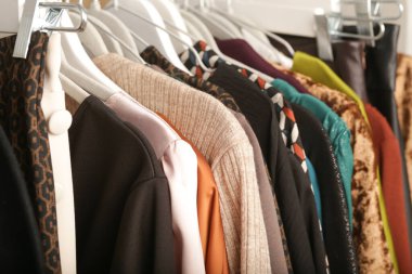 Kadın modası. Askılarda farklı kıyafetler, yakın çekim. İkinci el dükkanında ya da ikinci el mağazasında farklı kullanılmış kadın kıyafetlerinden bir sürü var. Moda endüstrisinde atık sorunu kavramı