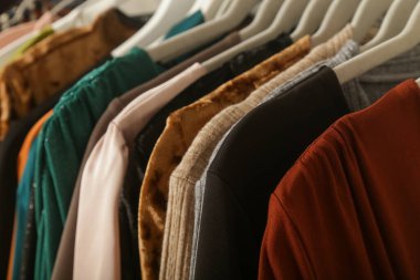 Kadın modası. Askılarda farklı kıyafetler, yakın çekim. İkinci el dükkanında ya da ikinci el mağazasında farklı kullanılmış kadın kıyafetlerinden bir sürü var. Moda endüstrisinde atık sorunu kavramı