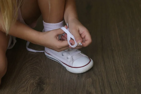 Ребенок Завязывает Ботинки Маленькая Девочка Изо Сил Пытается Завязать Шнурки — стоковое фото