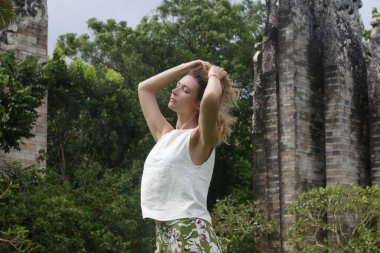 Genç bir kadın parkta rüzgarlı ve temiz havanın keyfini çıkarıyor, açık havada keten elbiseli şık bir kadının portresi, bahar-yaz moda modası