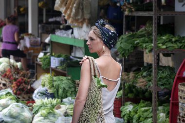 Endonezya, Bali 'deki yerel pazardan sebze alan Kafkas turist kadın