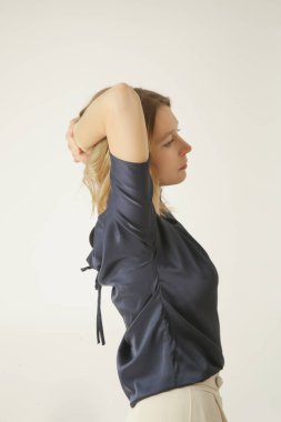 Stüdyo fotoğrafları, sade güzel kıyafetler, ipek saten bluz ve beyaz geniş paça pantolon giyen genç kadın modeller. 