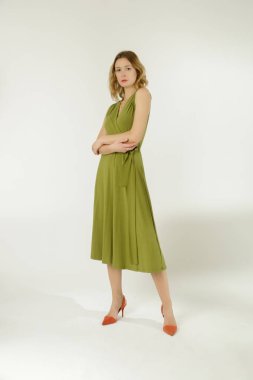 Stüdyo fotoğraflarının serisi. Yeşil yapışkan elbise giyen genç bir kadın model.. 