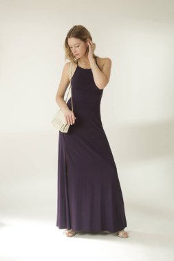 Uzun dar mor formalı kadın modelin stüdyo moda portresi.