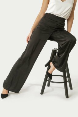 Stüdyo fotoğrafları, siyah beyaz ipekten elbiseler, gecelikler ve geniş paçalı pantolonlar giyen genç kadın modeller.