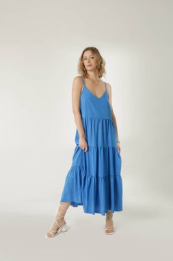 Stüdyo fotoğrafları. Mavi, uzun gecelikli genç bayan modelin fotoğrafları. Gündelik ve şık yaz kıyafetleri, bahar-yaz moda trendi.