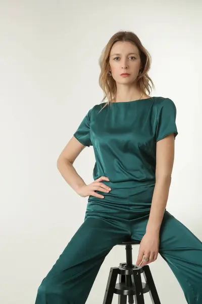 stock image Serie of studio photos of young female model in green silk outfit.