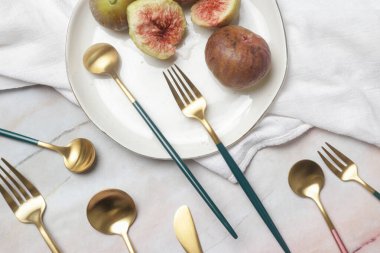 Mermer masadaki altın çatal bıçakların yaratıcı çekimi, tasarım konsepti. Modern mutfak. İskandinav tarzı sofra takımı.