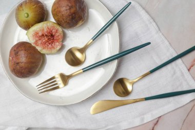 Mermer masadaki altın çatal bıçakların yaratıcı çekimi, tasarım konsepti. Modern mutfak. İskandinav tarzı sofra takımı.